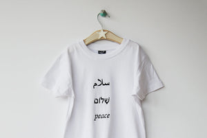 Salaam Shalom Peace in Arabic, Hebrew & English. White T-shirt with Black Writing. Simple and Minimal. Capsule Wardrobe.