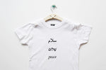 Salaam Shalom Peace in Arabic, Hebrew & English. White T-shirt with Black Writing. Simple and Minimal. Capsule Wardrobe.